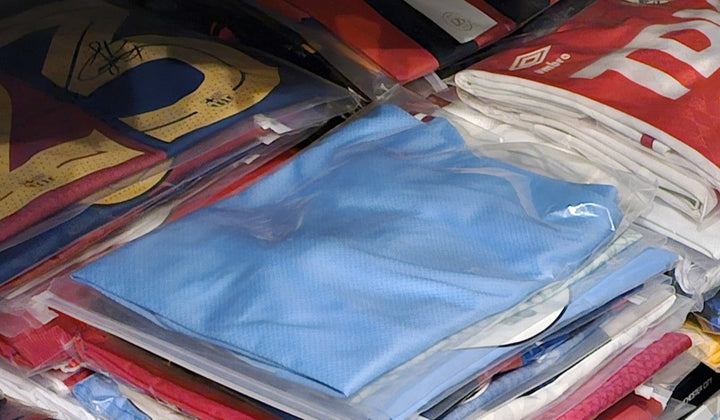 Collection of authenticated signed football shirts neatly stored in protective sleeves, illustrating how to choose autographed jerseys with confidence.