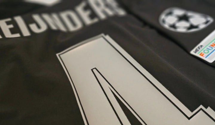 Namesets and competition patches on a signed football shirt. The details that have to match the competition the shirt claims.
