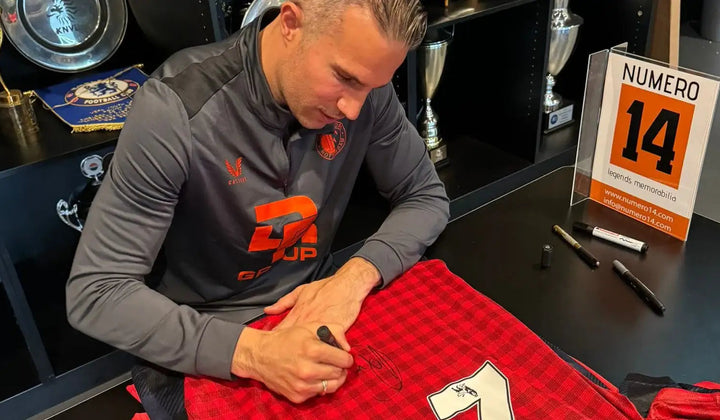Robin van Persie signing a red Manchester United football shirt, captured with Exact Photo Proof during a signing session, ensuring authenticity for collectors.