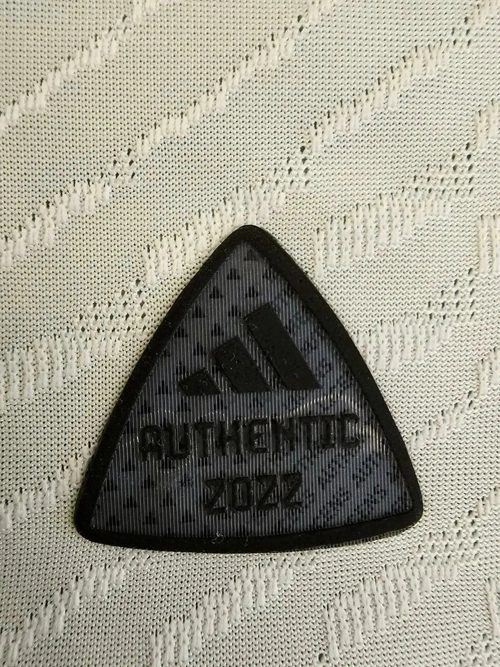 Adidas authenticity patch showing &