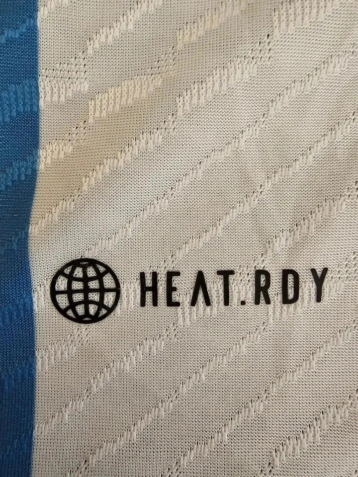 Detail showing HEAT.RDY label on the white and blue soccer jersey.