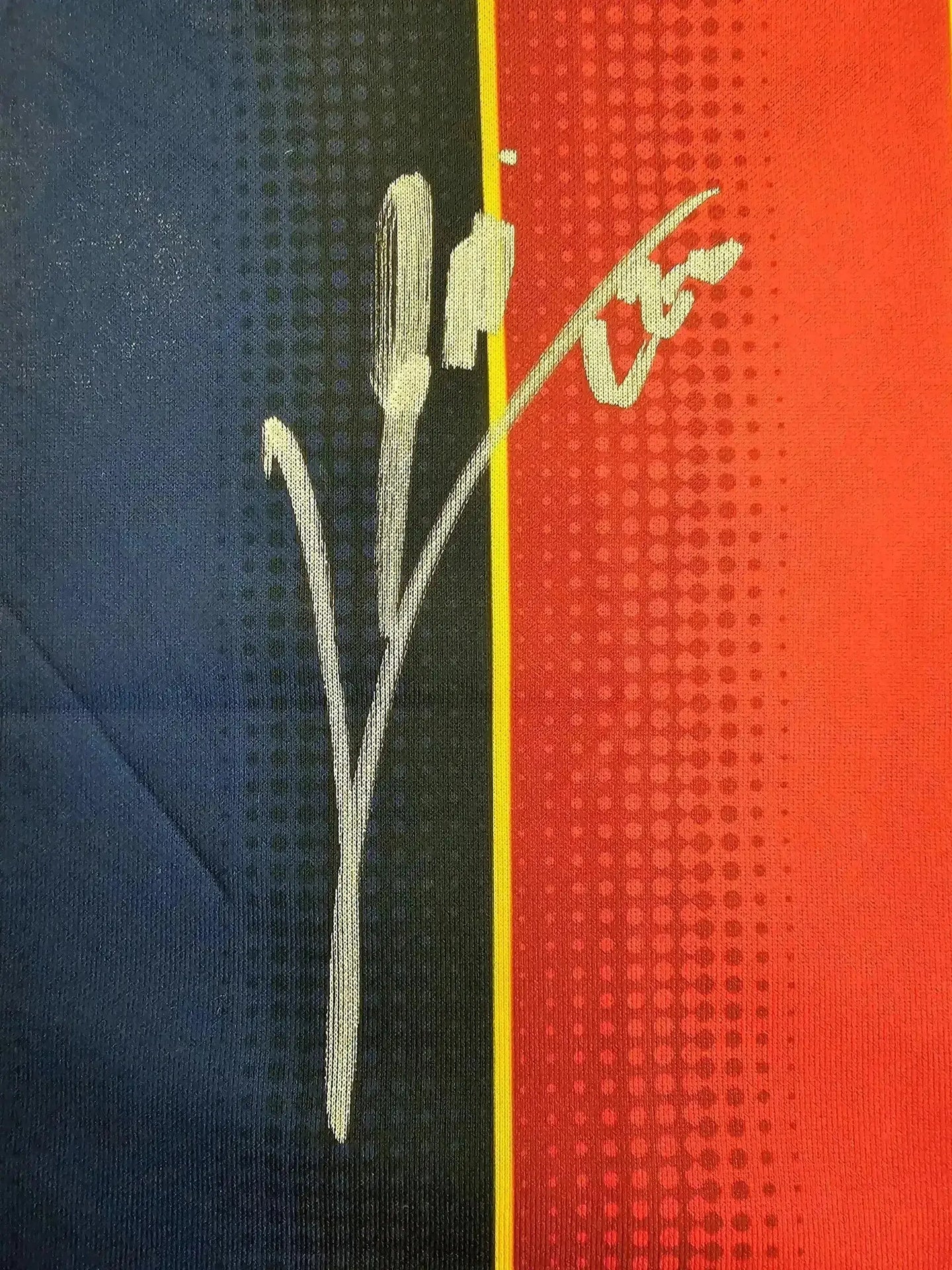 Close-up of Lionel Messi's signature on Barcelona 2020-2021 home soccer jersey's blue and red design.