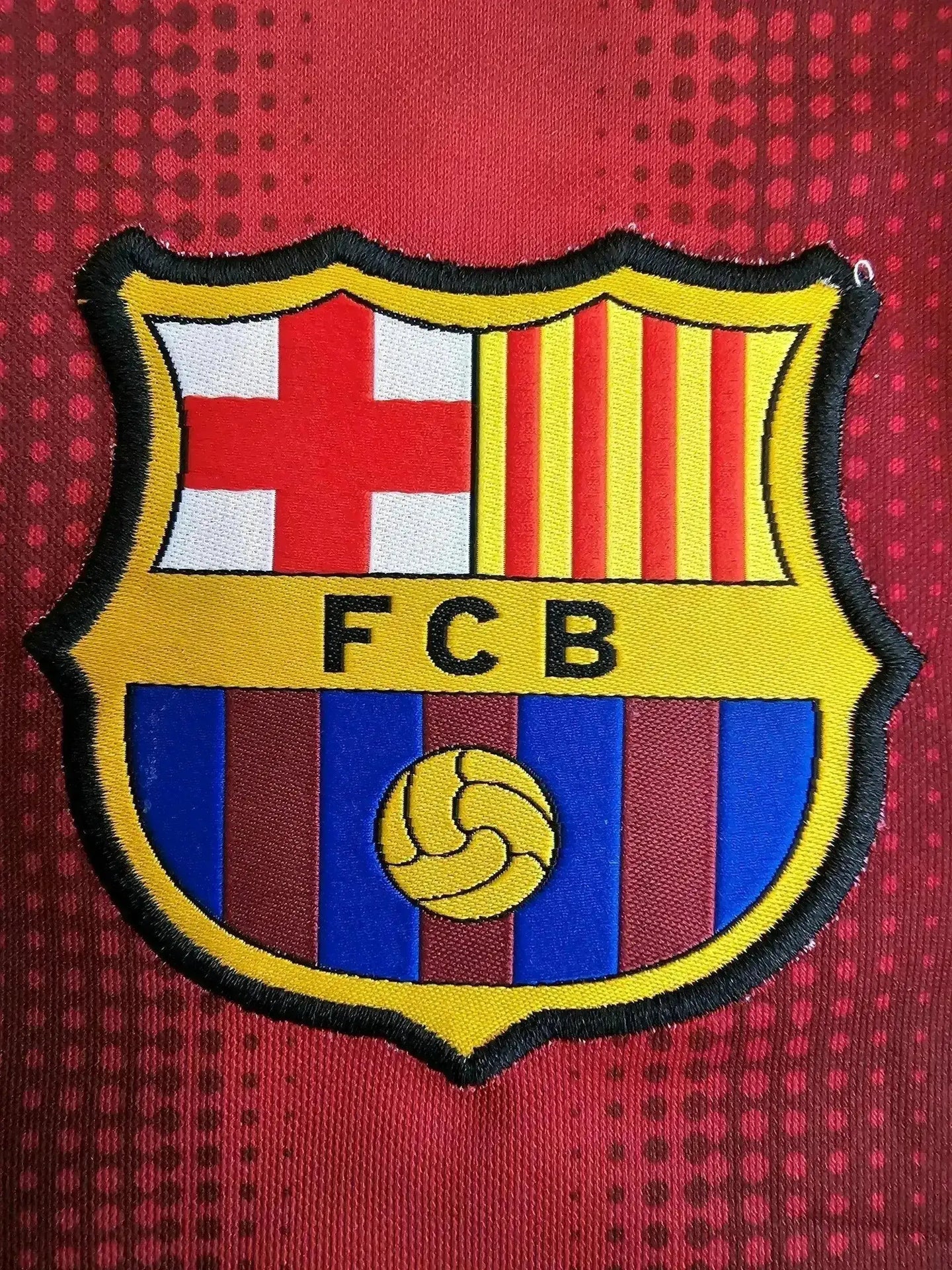 FC Barcelona crest featuring the shield, red and blue stripes, and golden ball detail.