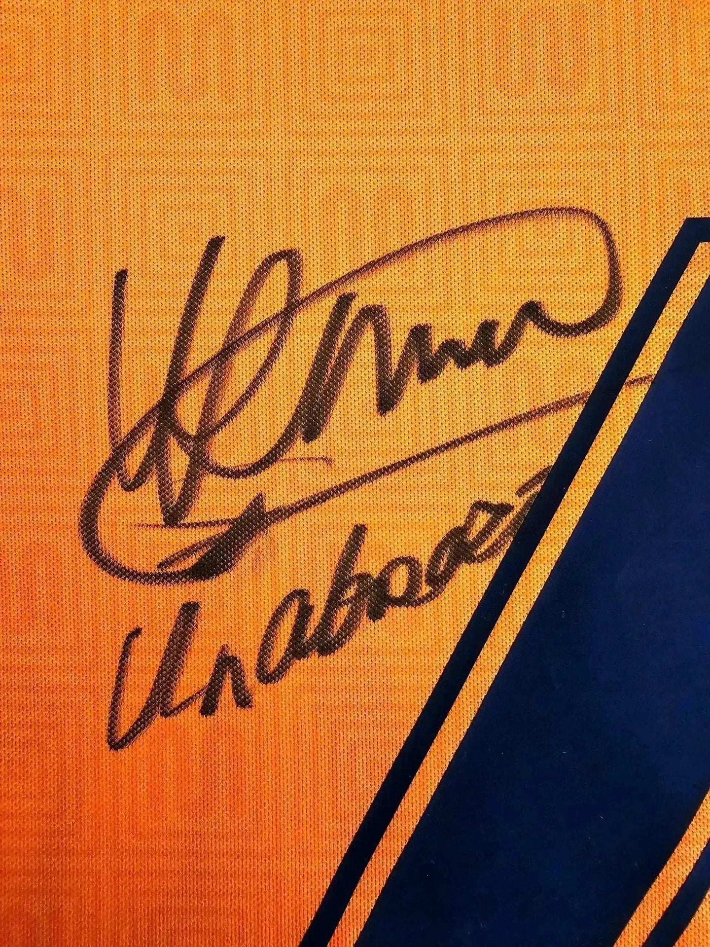 Signature detail showing Ronald Koeman's autograph on the orange Barcelona 1991-1992 away shirt.
