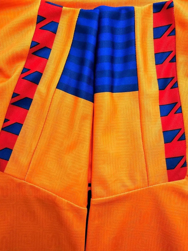 Back view featuring vibrant orange, blue, and red detailing with pleats.