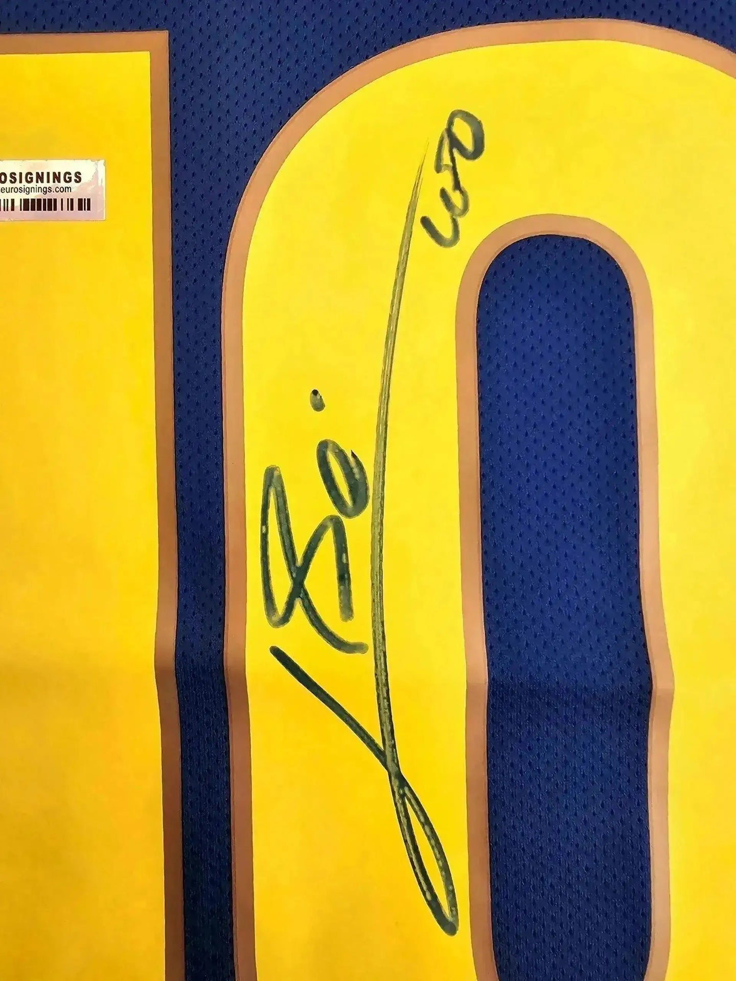 Detail view showing signature on No. 10 of signed soccer jersey.