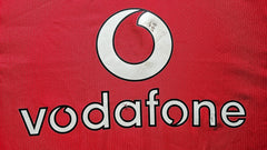 Detail of the red soccer jersey featuring the Vodafone wordmark prominently displayed.