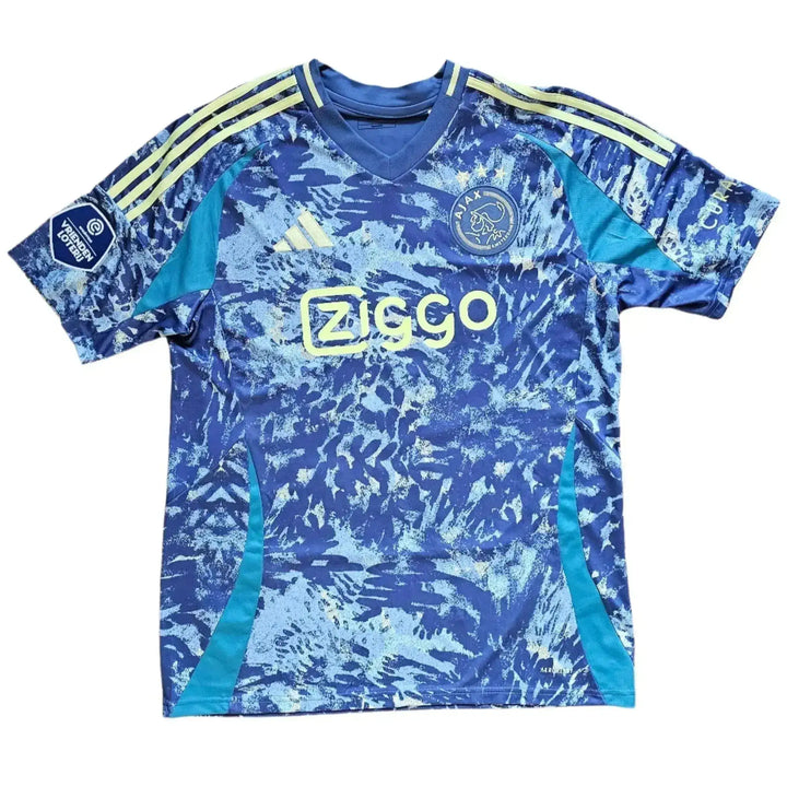 Front view of signed football shirt in blue and yellow with Ziggo logo and Ajax crest.