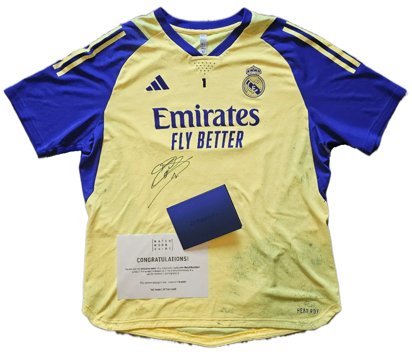 Front view of Thibaut Courtois signed Real Madrid football shirt in yellow and navy with Emirates branding.