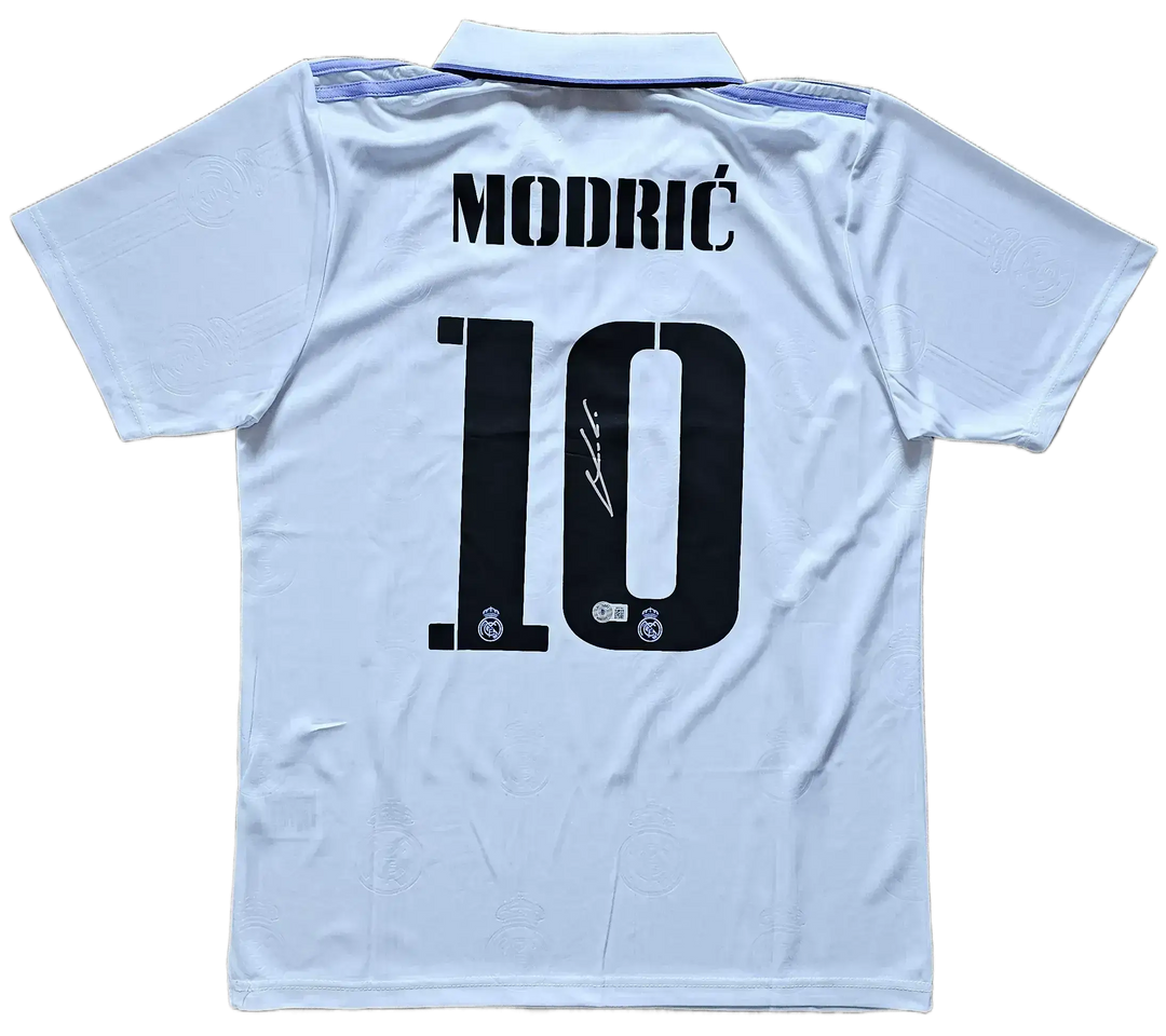 Back view featuring Modrić, No. 10 and a visible signature on a white soccer jersey.