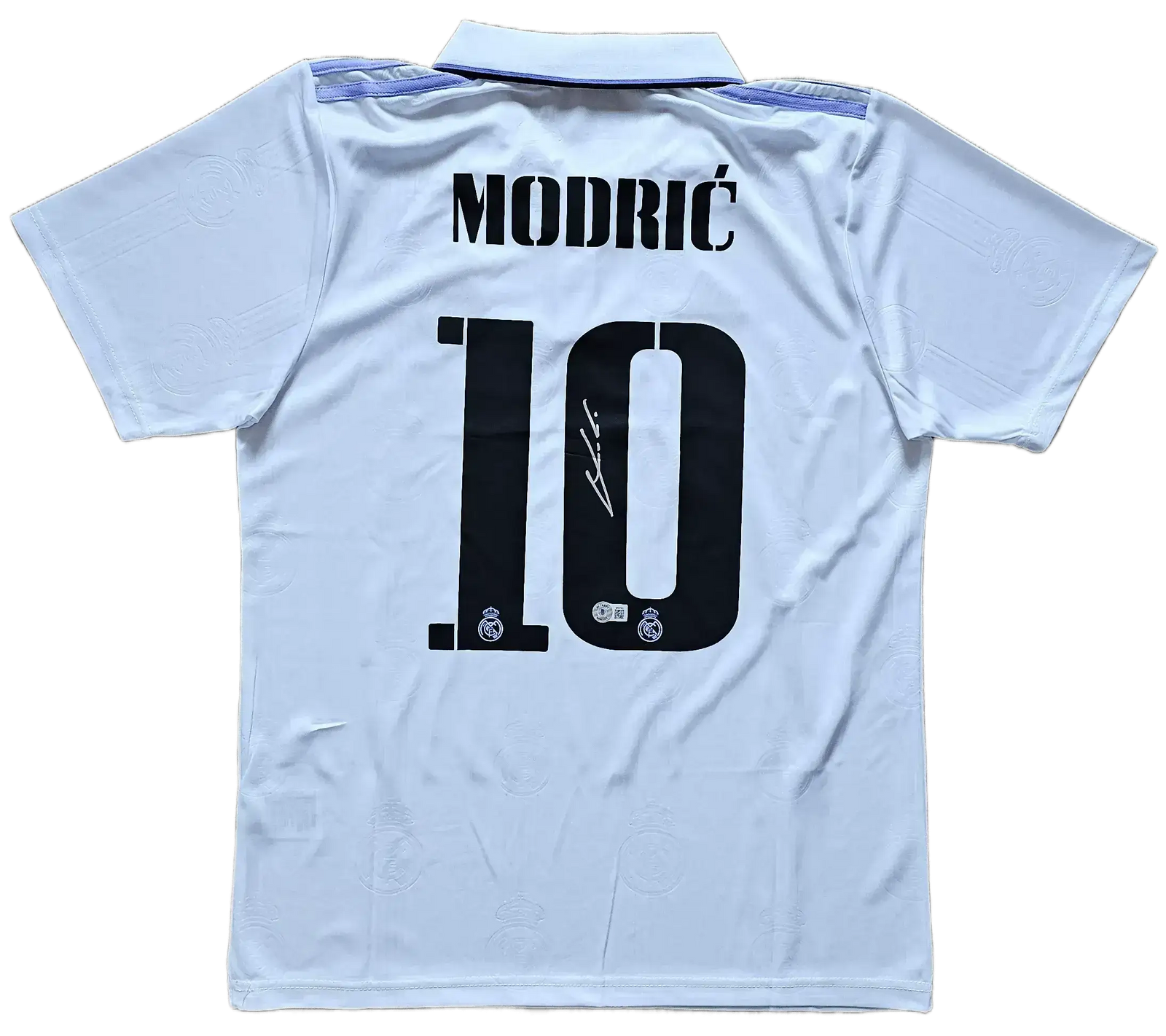Back view featuring Modrić, No. 10 and a visible signature on a white soccer jersey.