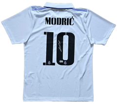 Back view featuring Modrić, No. 10 and a visible signature on a white soccer jersey.