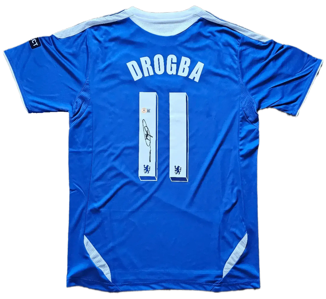 Back view featuring DROGBA, No. 11, and a signature on a blue soccer jersey.