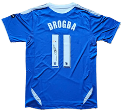 Back view featuring DROGBA, No. 11, and a signature on a blue soccer jersey.