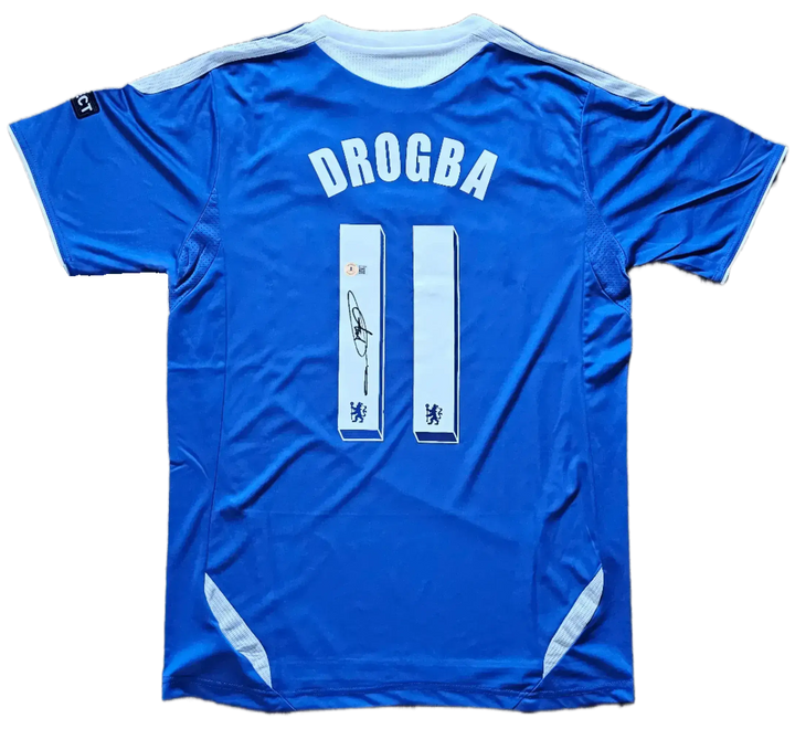 Back view featuring DROGBA, No. 11, and a signature on a blue soccer jersey.