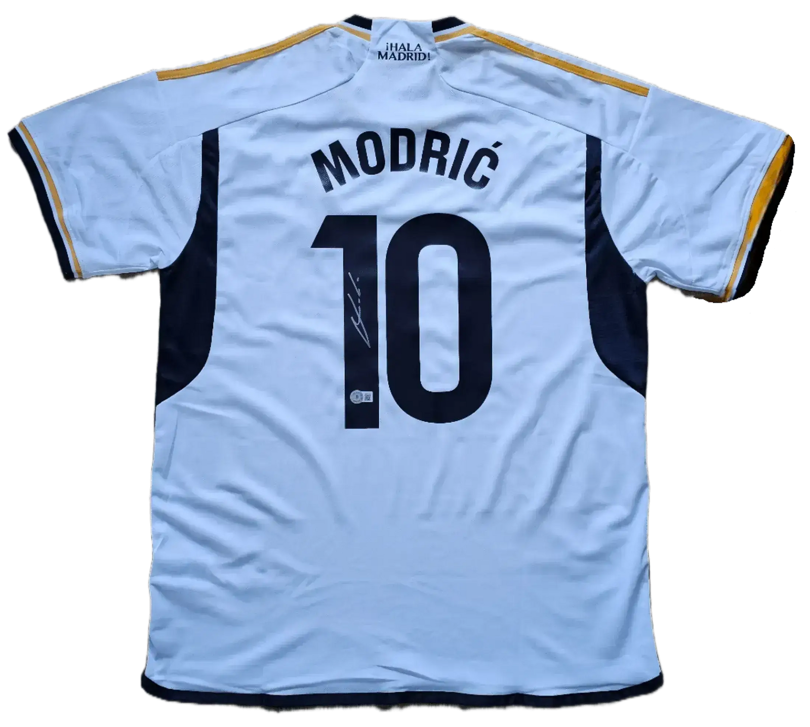Back view showing Modrić, No. 10, and visible signature on a white football shirt.