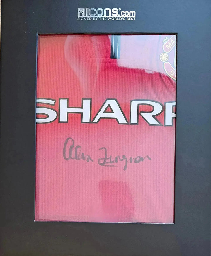 Red Manchester United football shirt featuring signature of Alex Ferguson and Sharp logo.