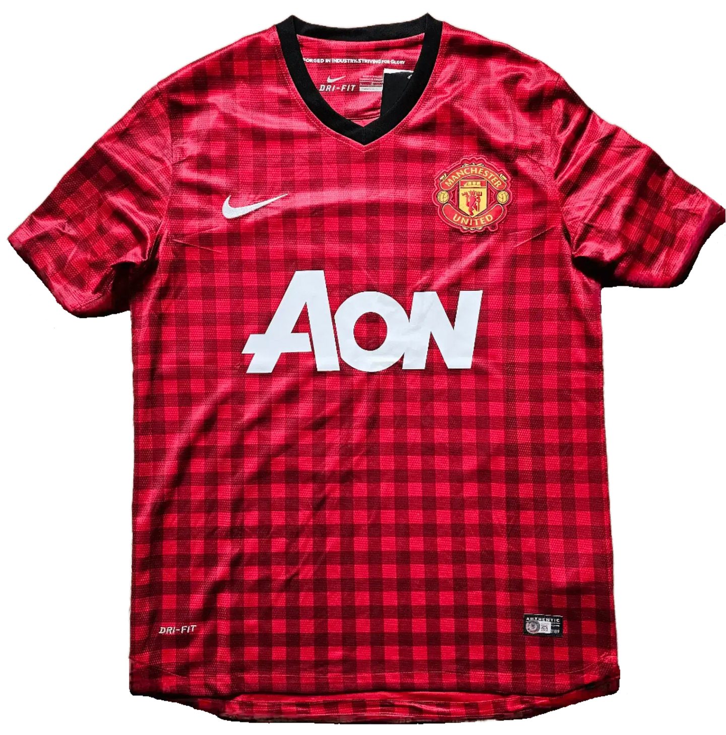 Front view of red checkered Manchester United F.C. soccer jersey with Aon sponsor and Nike emblem.