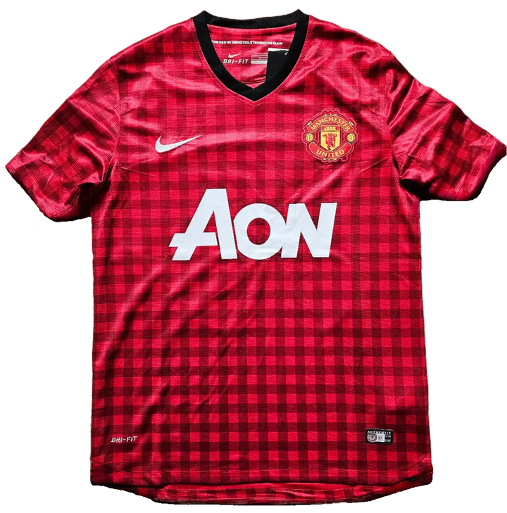 Front view of red checkered Manchester United F.C. soccer jersey with Aon sponsor and Nike emblem.