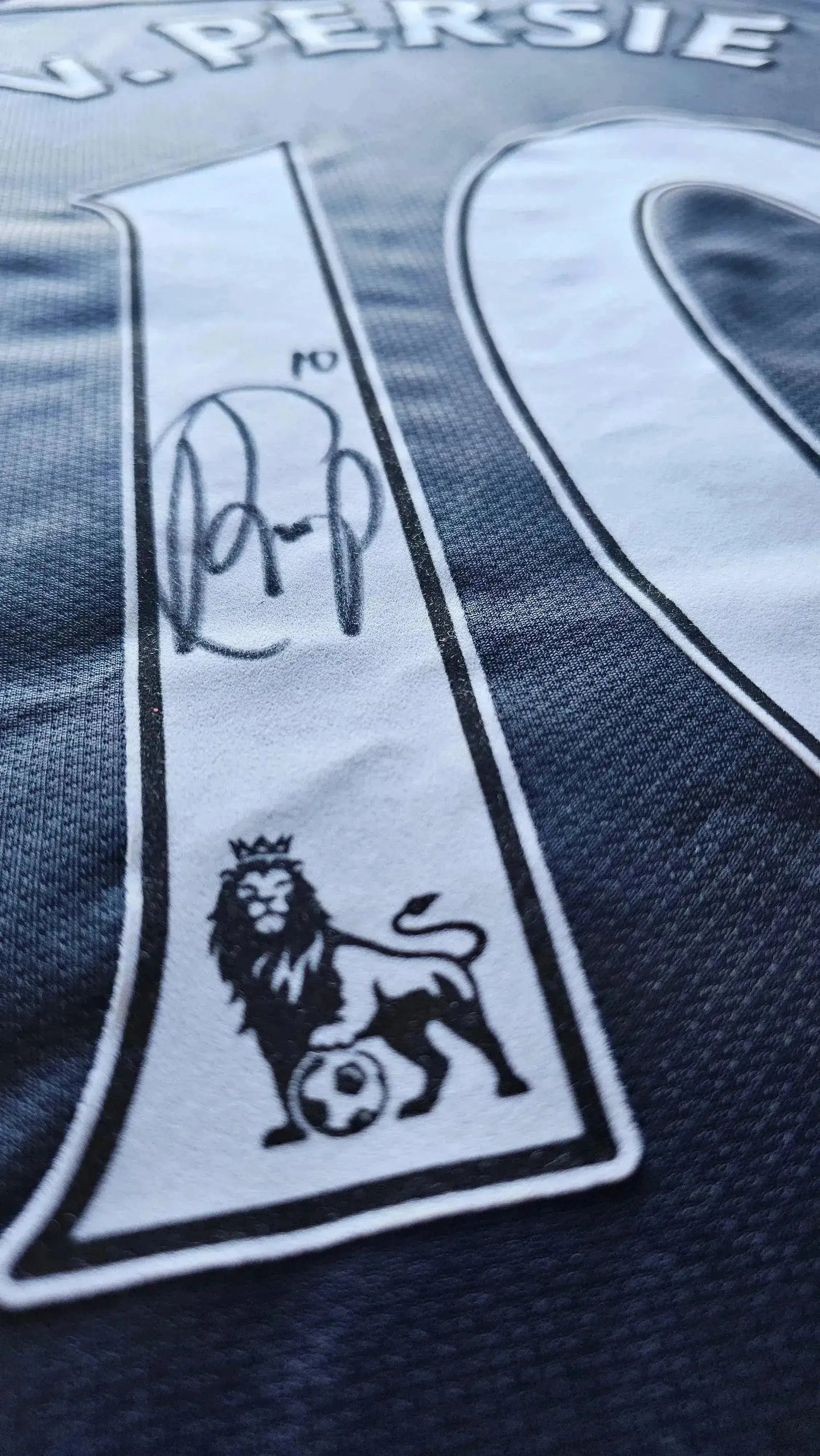 Detail view of No. 10 with signature and lion emblem on Robin van Persie soccer jersey.