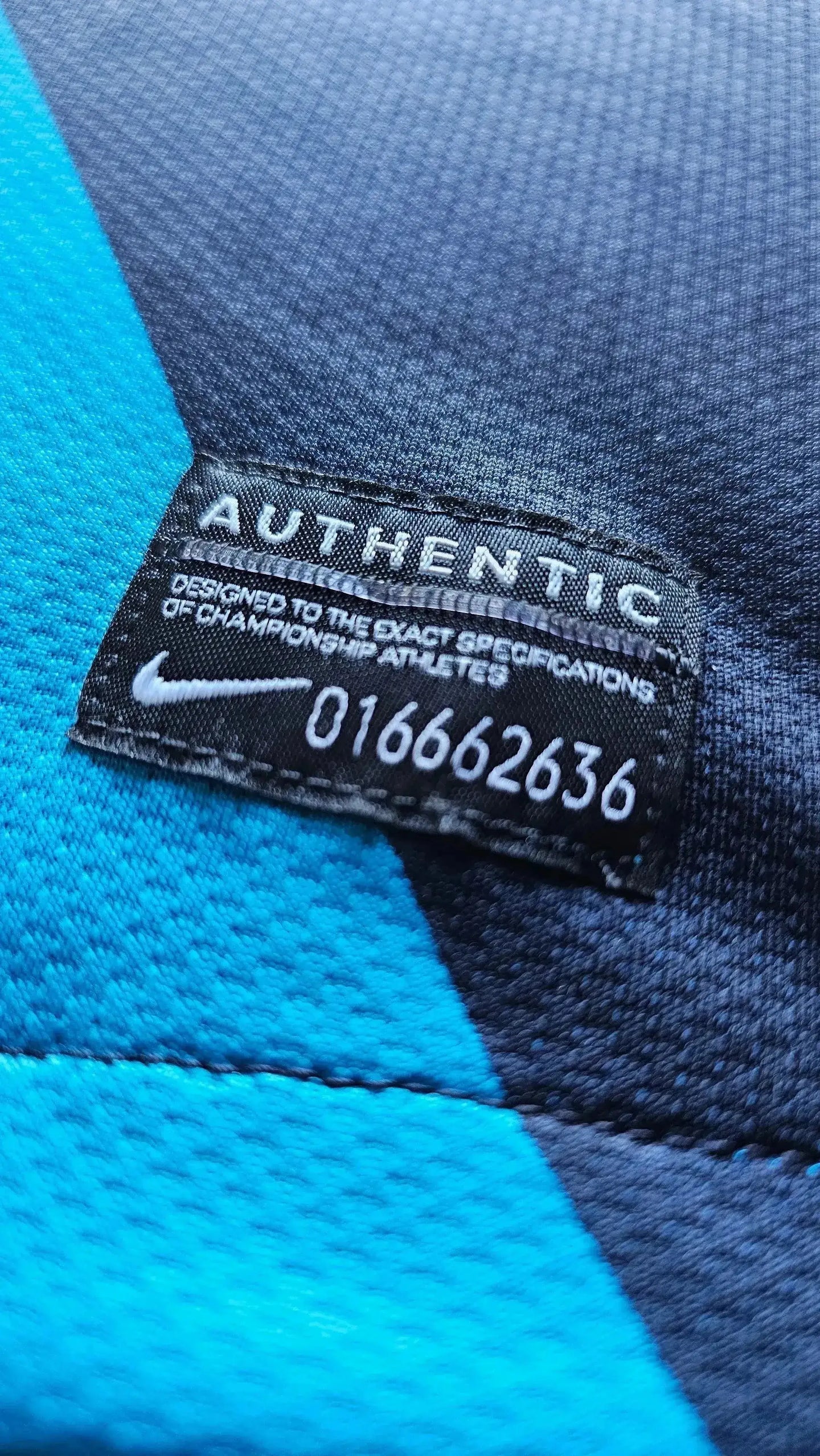 Close-up of the label showing 'AUTHENTIC' and 'DESIGNED TO THE EXACT SPECIFICATIONS OF CHAMPIONSHIP ATHLETES' with Nike logo.