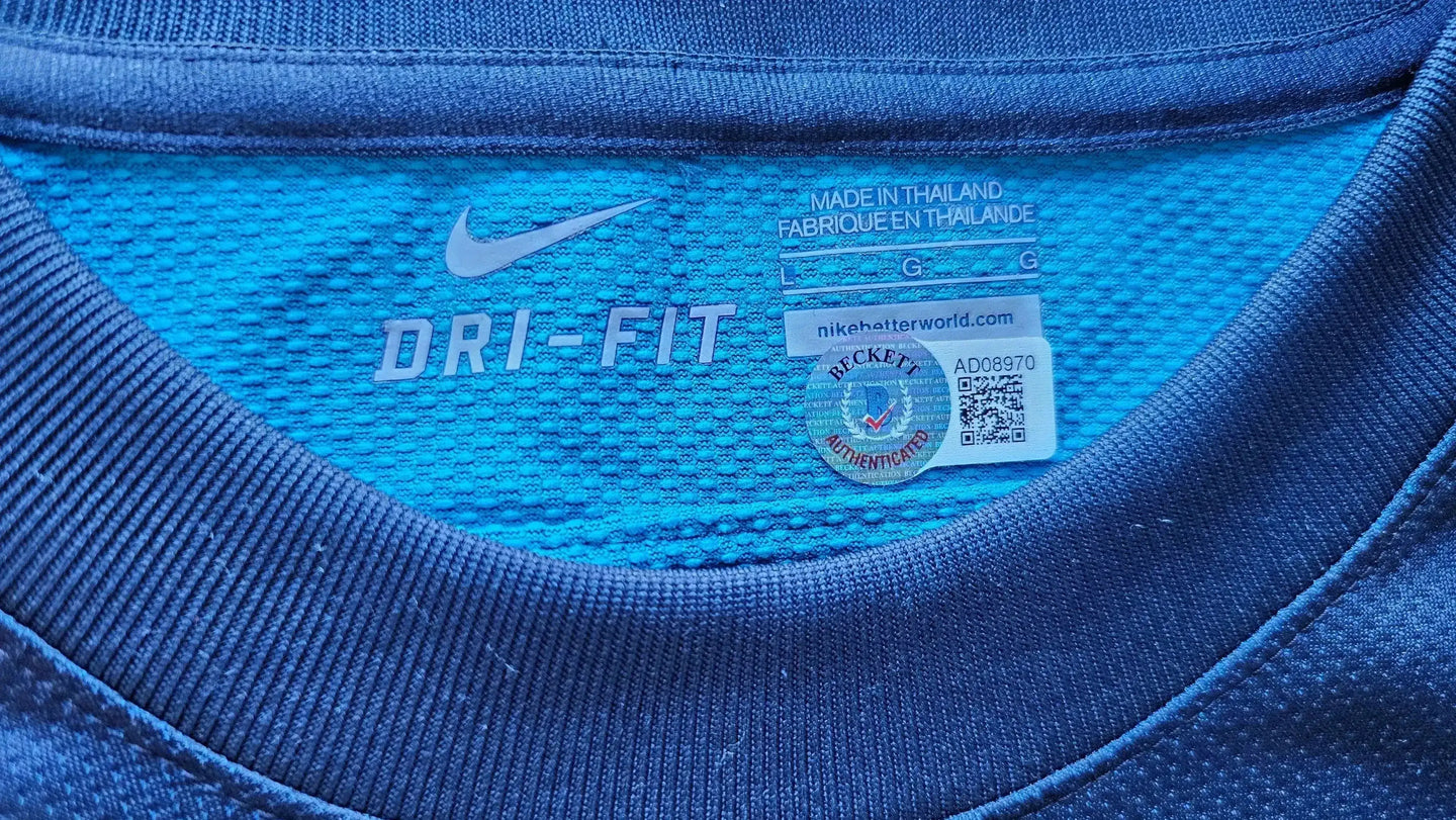 Close-up view of care label featuring DRI-FIT text and authenticating sticker.