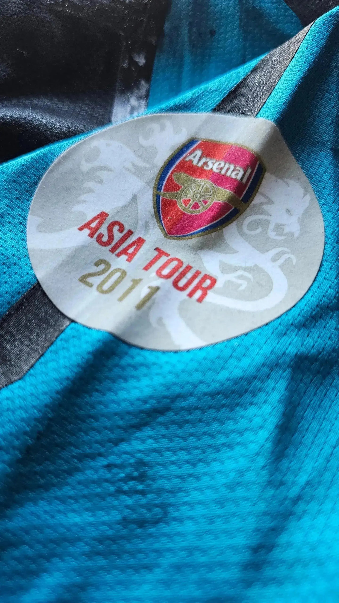 Arsenal crest and Asia Tour 2011 detail on a navy soccer jersey.