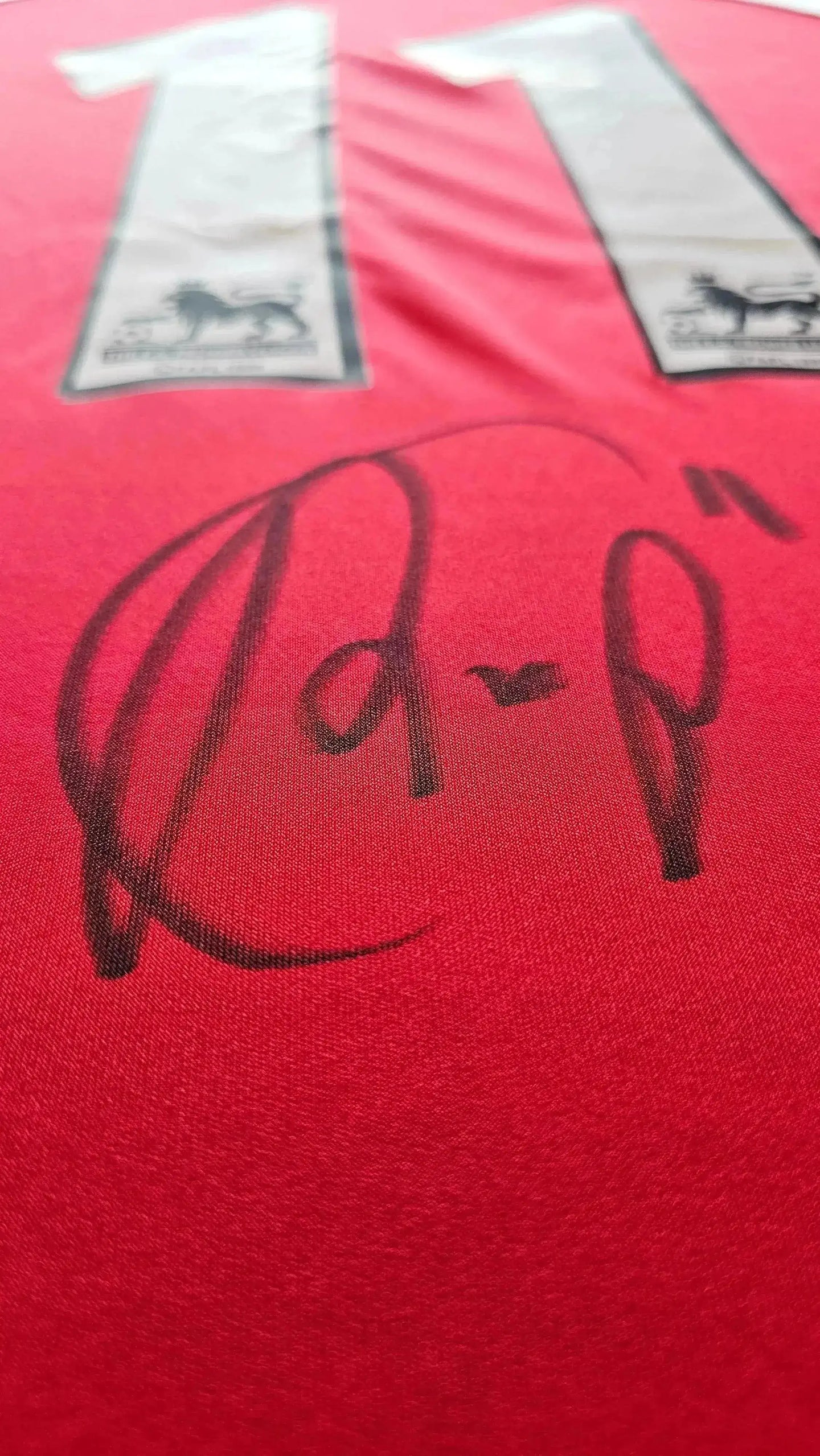 Detail view featuring the signature of Robin van Persie on a red football shirt No. 11.