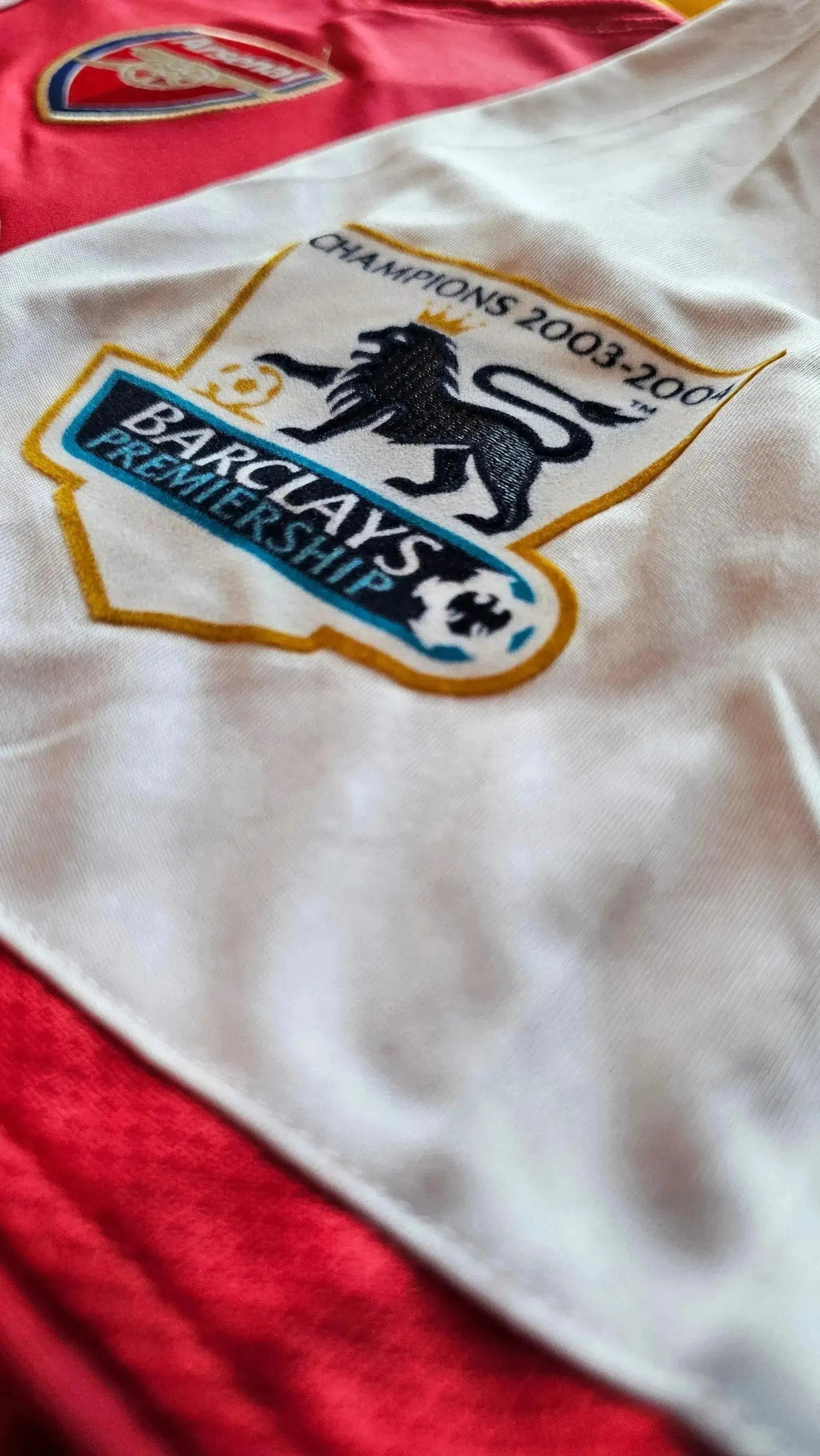 Close-up of Arsenal crest and Barclays Premiership detail with text Champions 2003-2004.