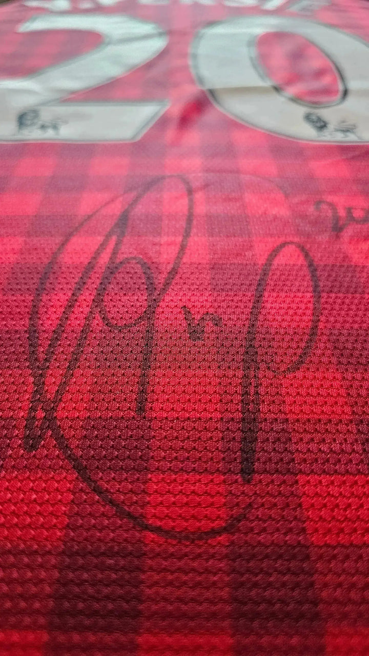 Close-up of the No. 20 and signature on a red Manchester United football shirt.