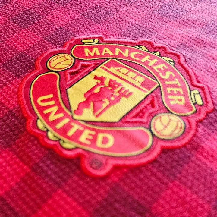 Close-up of the Manchester United crest with yellow and red detailing.