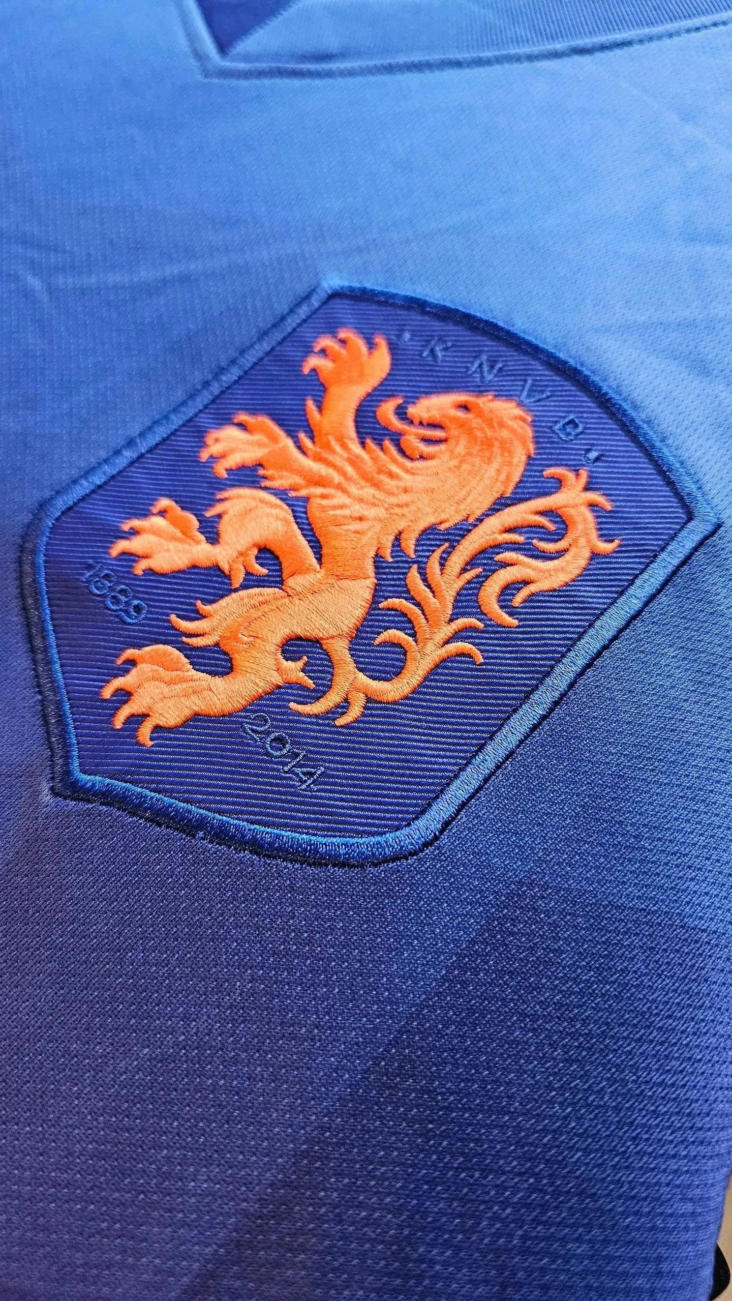 Crest detail featuring the orange lion emblem of the KNVB with dates 1863 and 2014.