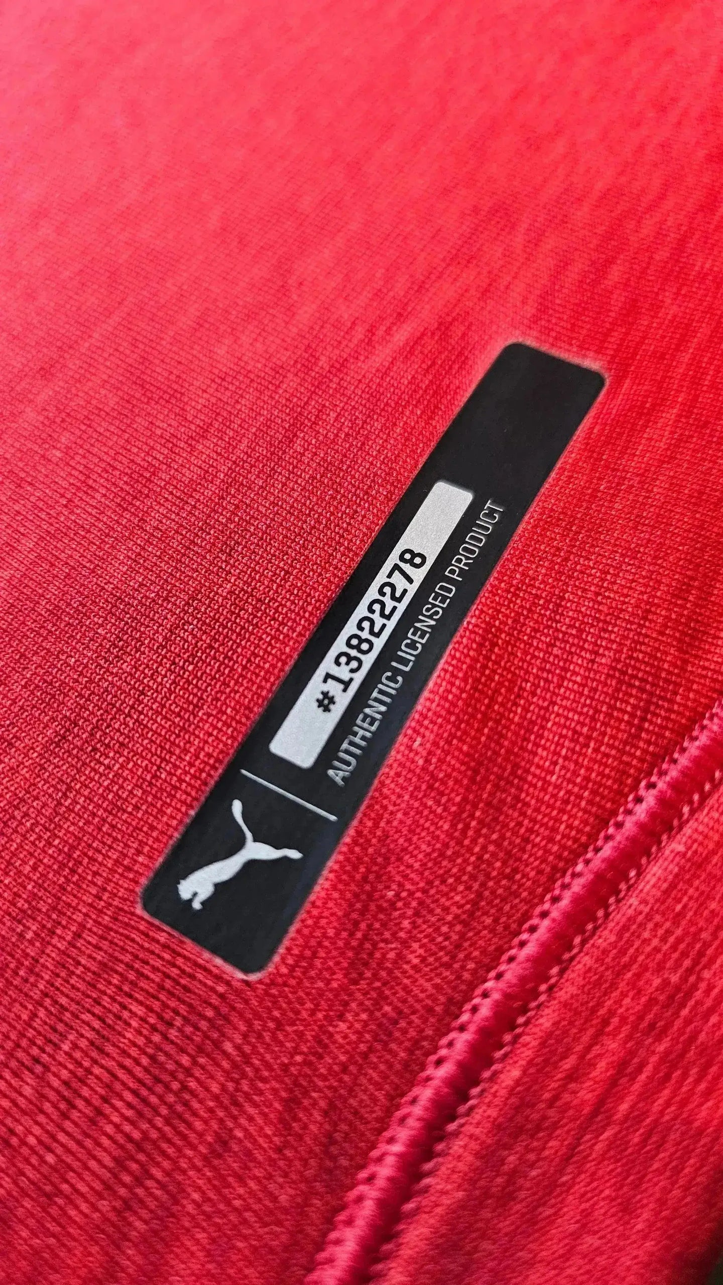 Detail view showing the authenticity tag with serial No. 13822278 on a red soccer jersey.