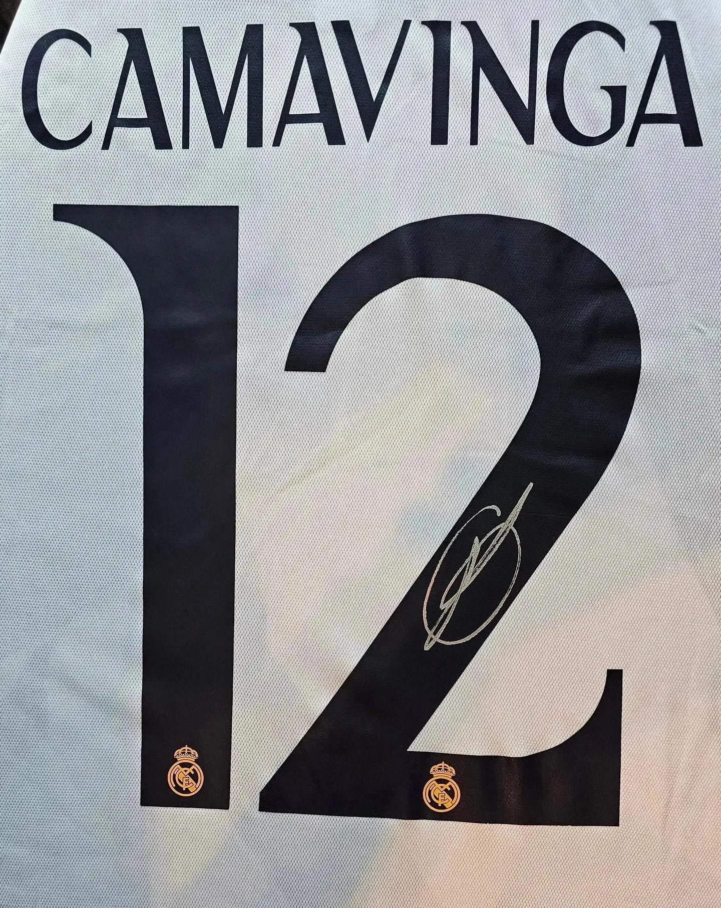 Back view showing No. 12, player name CAMAVINGA and signature detail with Real Madrid crest.