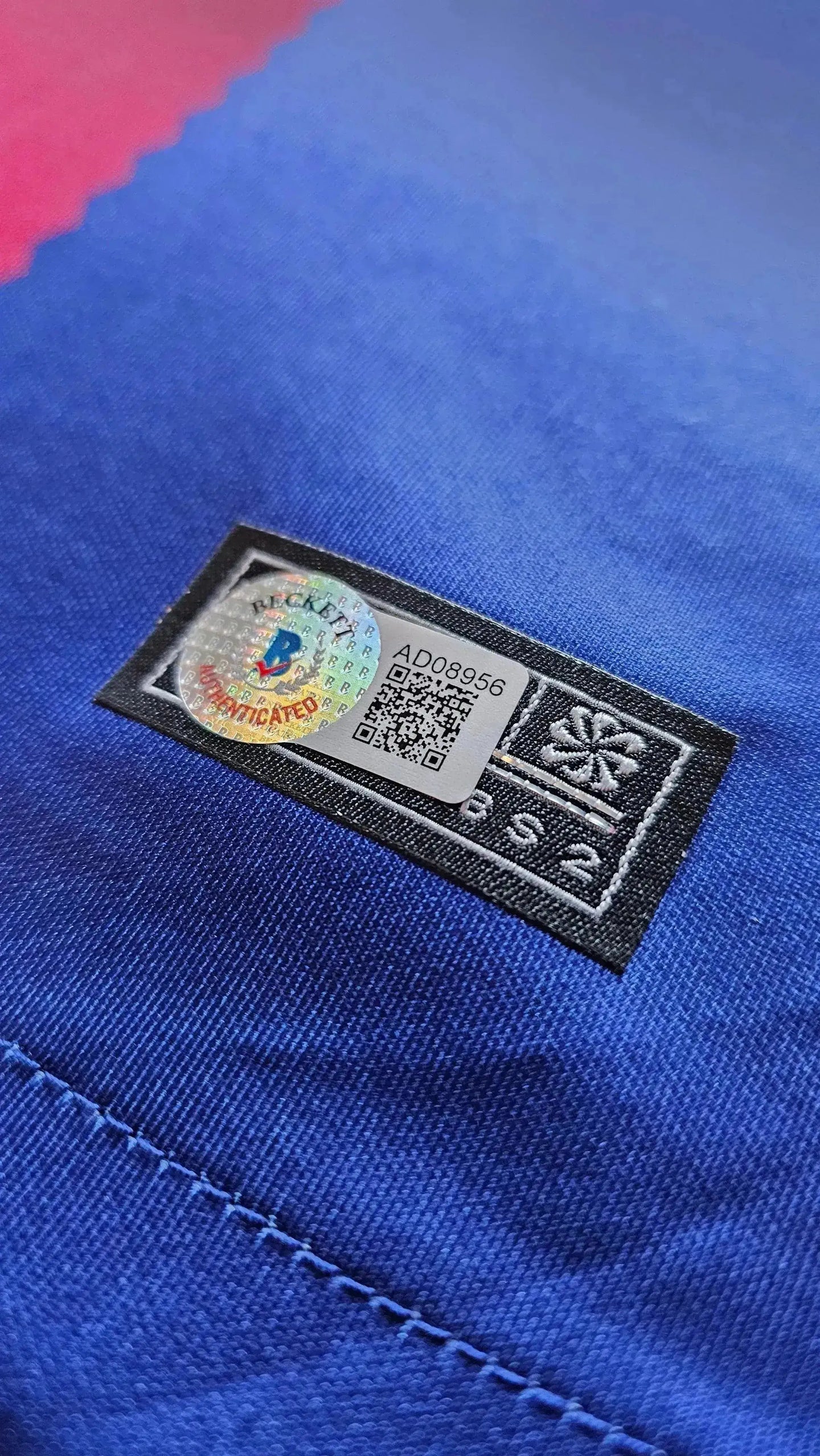 Beckett certified authenticity label on a blue and red striping detail.