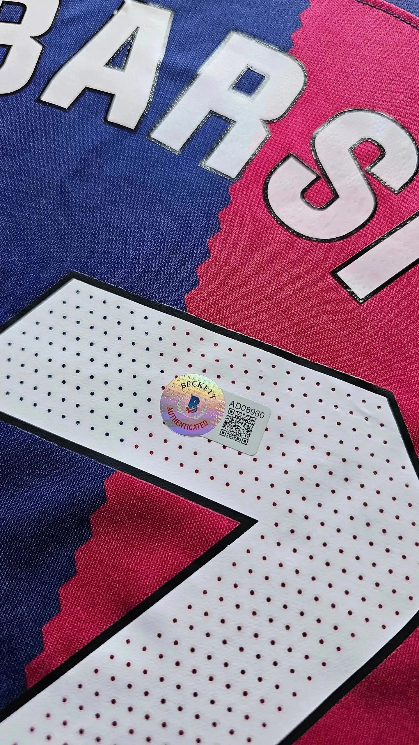 Close-up of the Beckett authentication sticker on a Barcelona football shirt, showing No. 7.