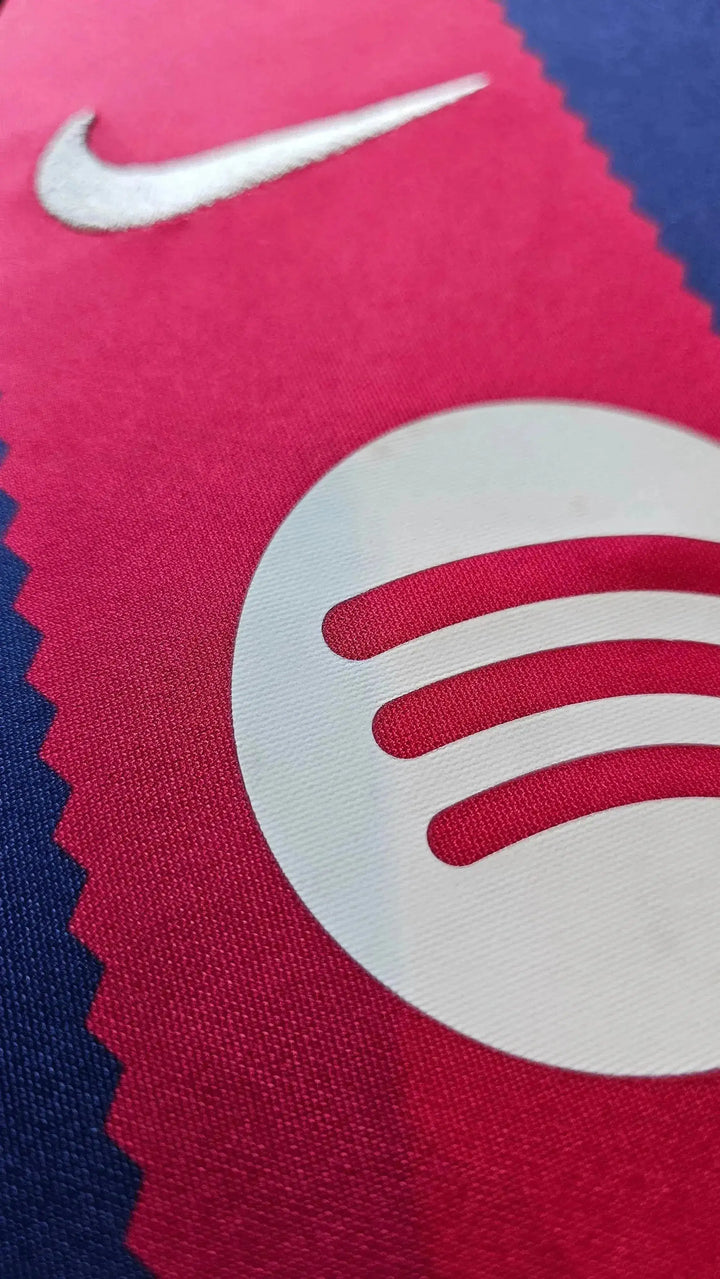 Close-up of the FC Barcelona crest in red and blue with the Nike logo and Spotify sponsor logo.