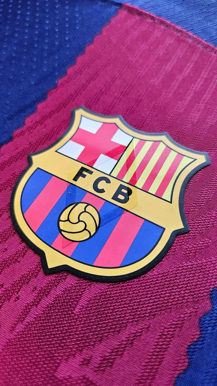 Close-up of FC Barcelona crest featuring gold border, red and blue stripes, and a soccer ball.