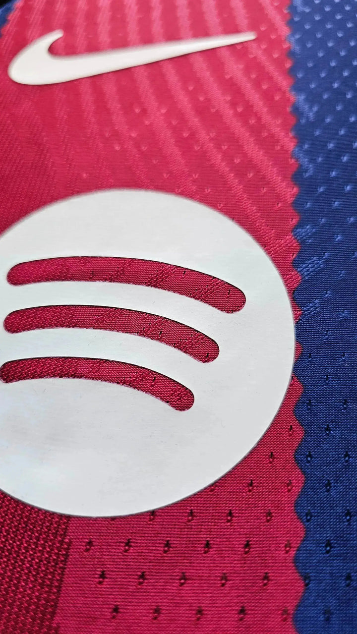 Close-up of Spotify logo on red and blue fabric with Nike swoosh above.