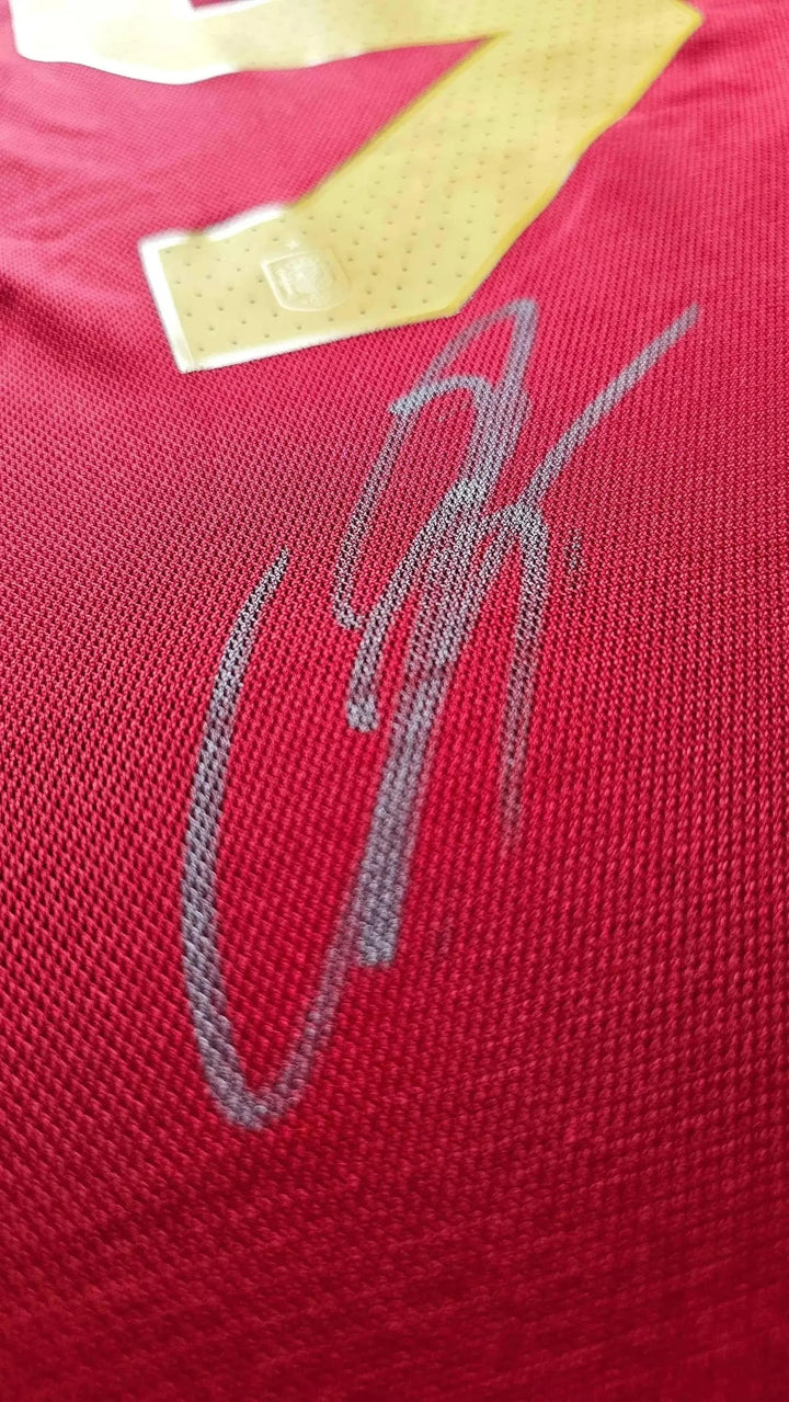 Close-up of Lamine Yamal's signature on the red Spain 2024 football shirt beneath the No. 19.