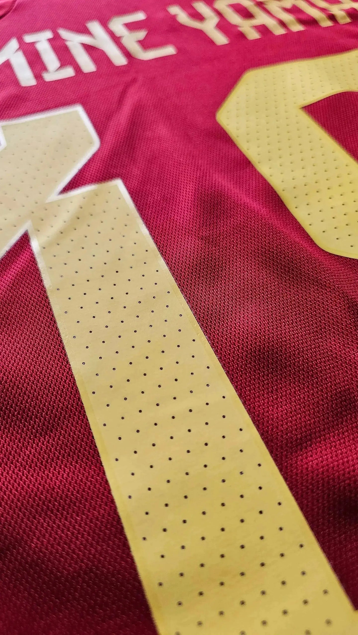 Close-up of Lamine Yamal's name and No. 19 in yellow on a red soccer jersey.
