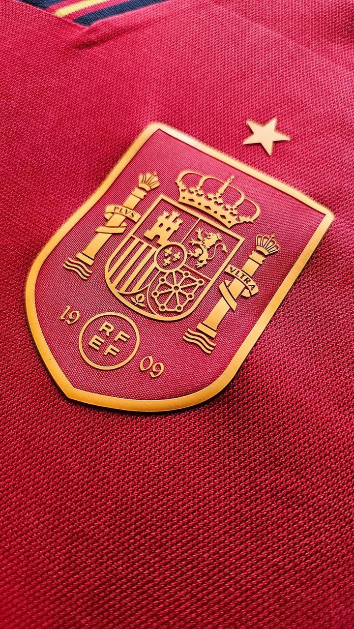 Crest detail featuring the Spain emblem with gold accents and a star above.