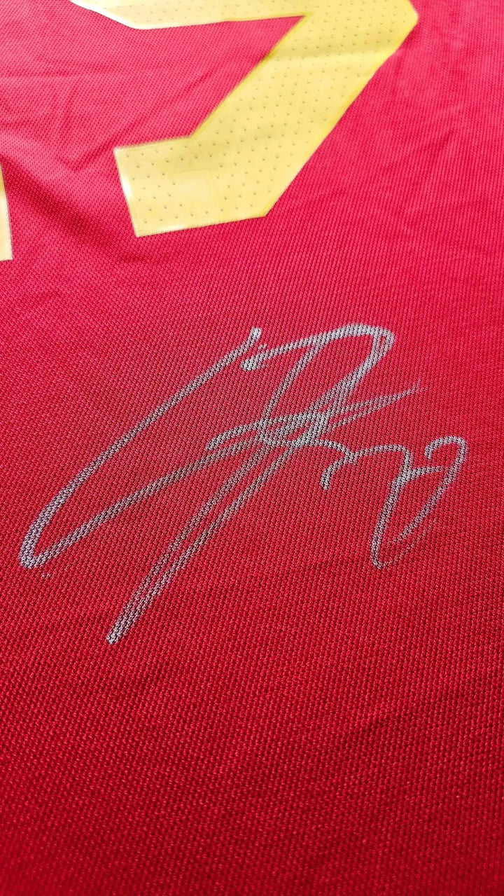 Close-up of signature detail on red football shirt featuring No. 19.