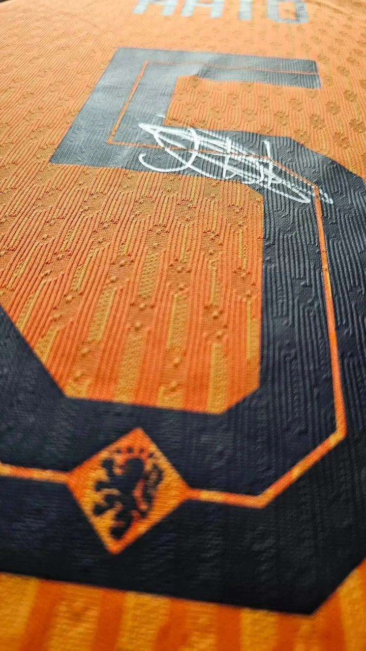 Close-up of the No. 5 with the signature of Jorrel Hato on an orange football shirt.