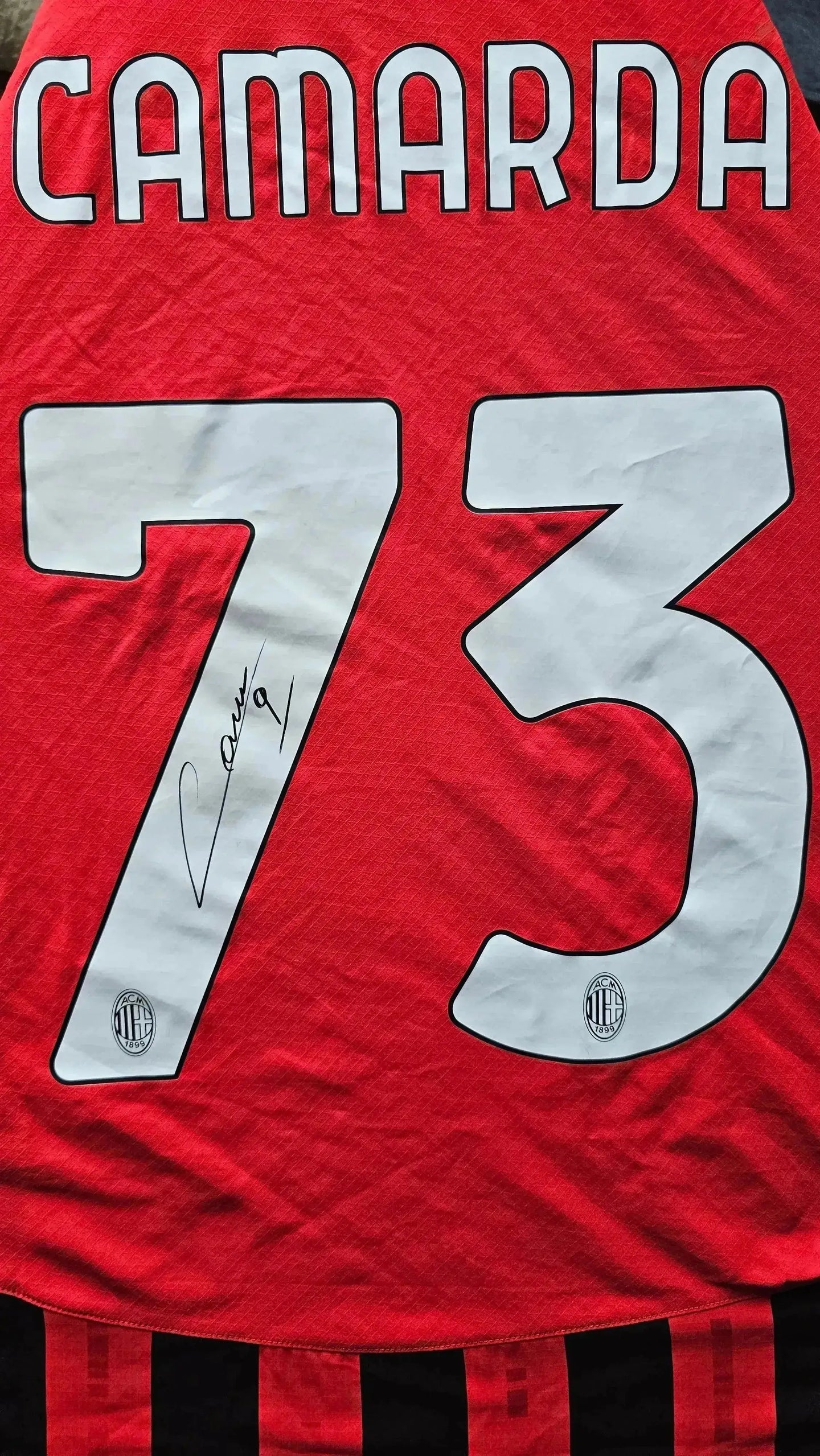 Back view showing name CAMARDA, No. 73, and signature on red and black football shirt.