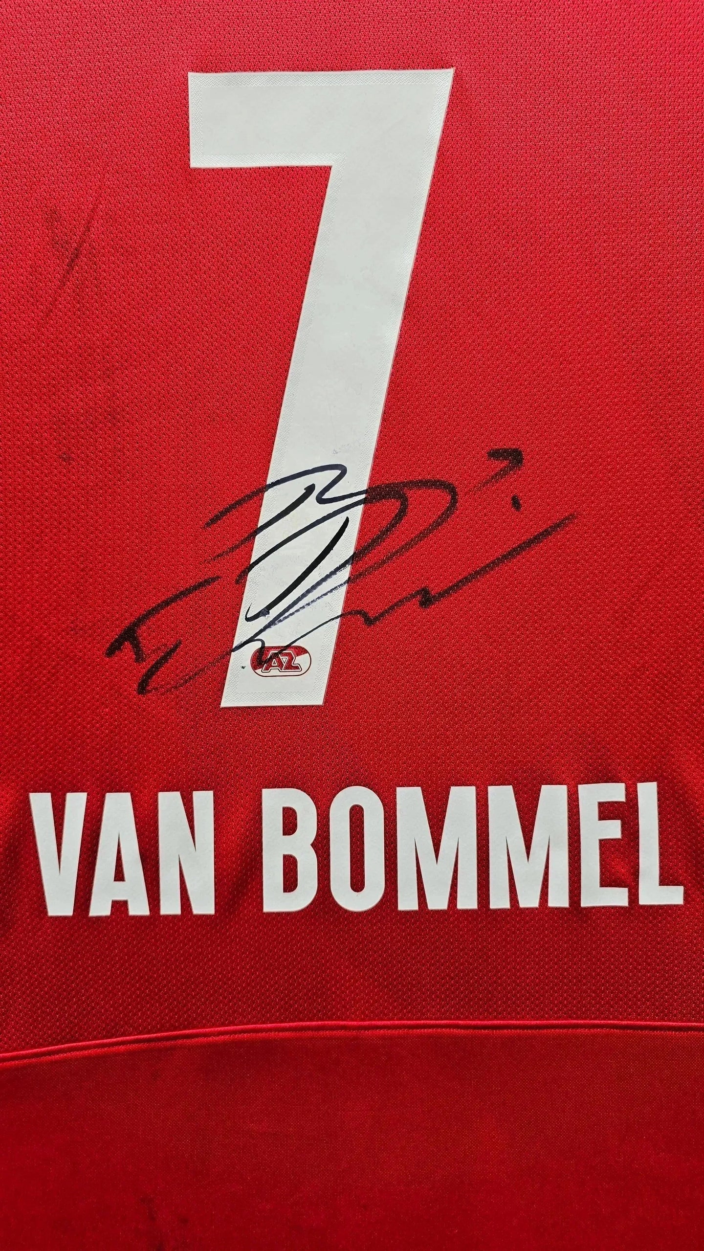 Detail view of red football shirt with No. 7 and signature of Van Bommel.