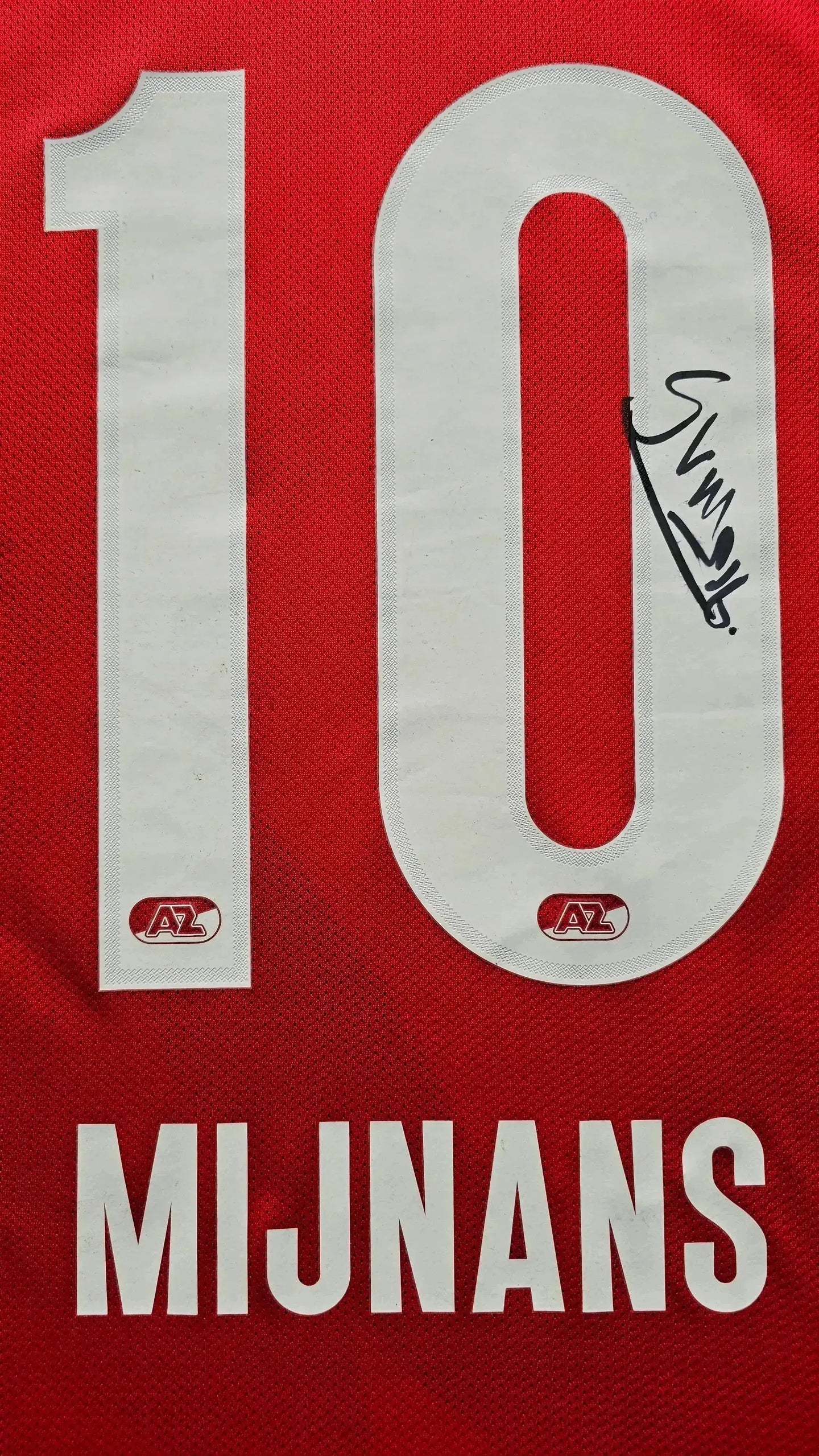 Back view showing No. 10, name Mijnans, and signature on a red AZ Alkmaar football shirt.