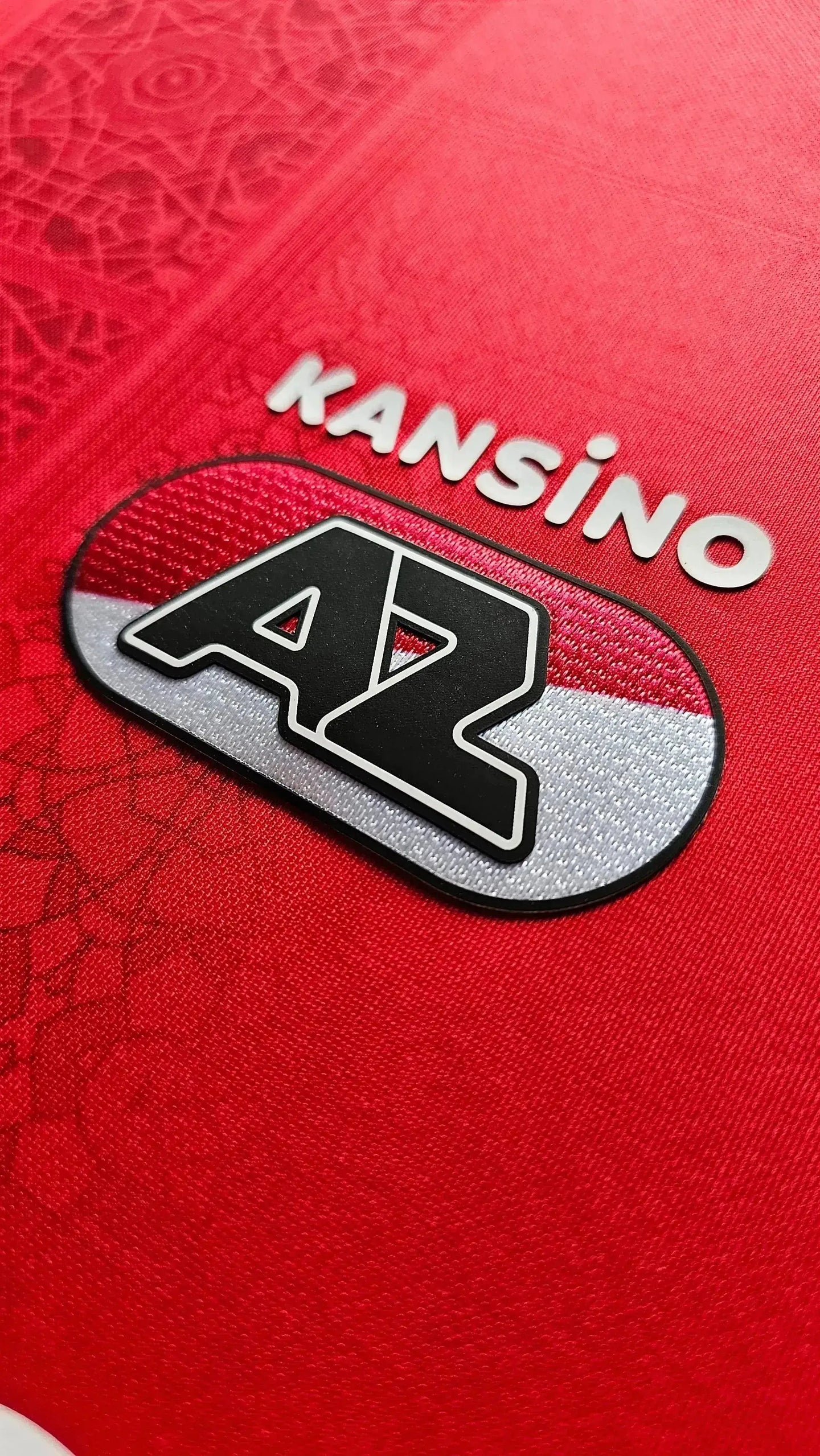 AZ Alkmaar crest detail featuring 'KANSINO' and red design elements.
