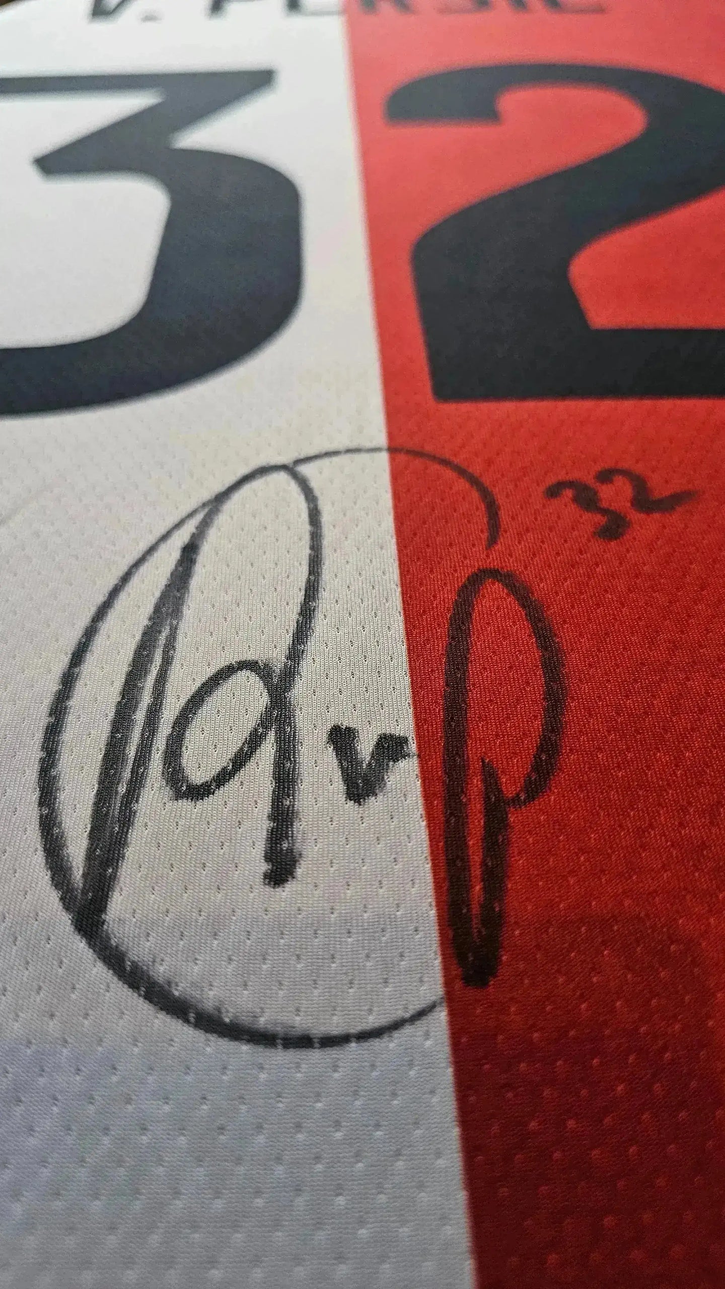 Close-up showing signature of Robin van Persie and No. 32 on football shirt.