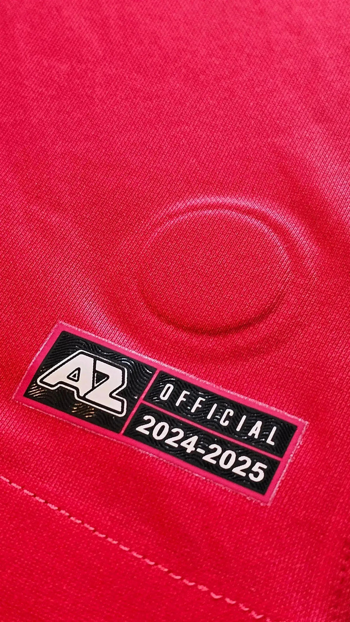 Close-up of AZ Alkmaar tag featuring 'OFFICIAL' and '2024-25' on a red football shirt.